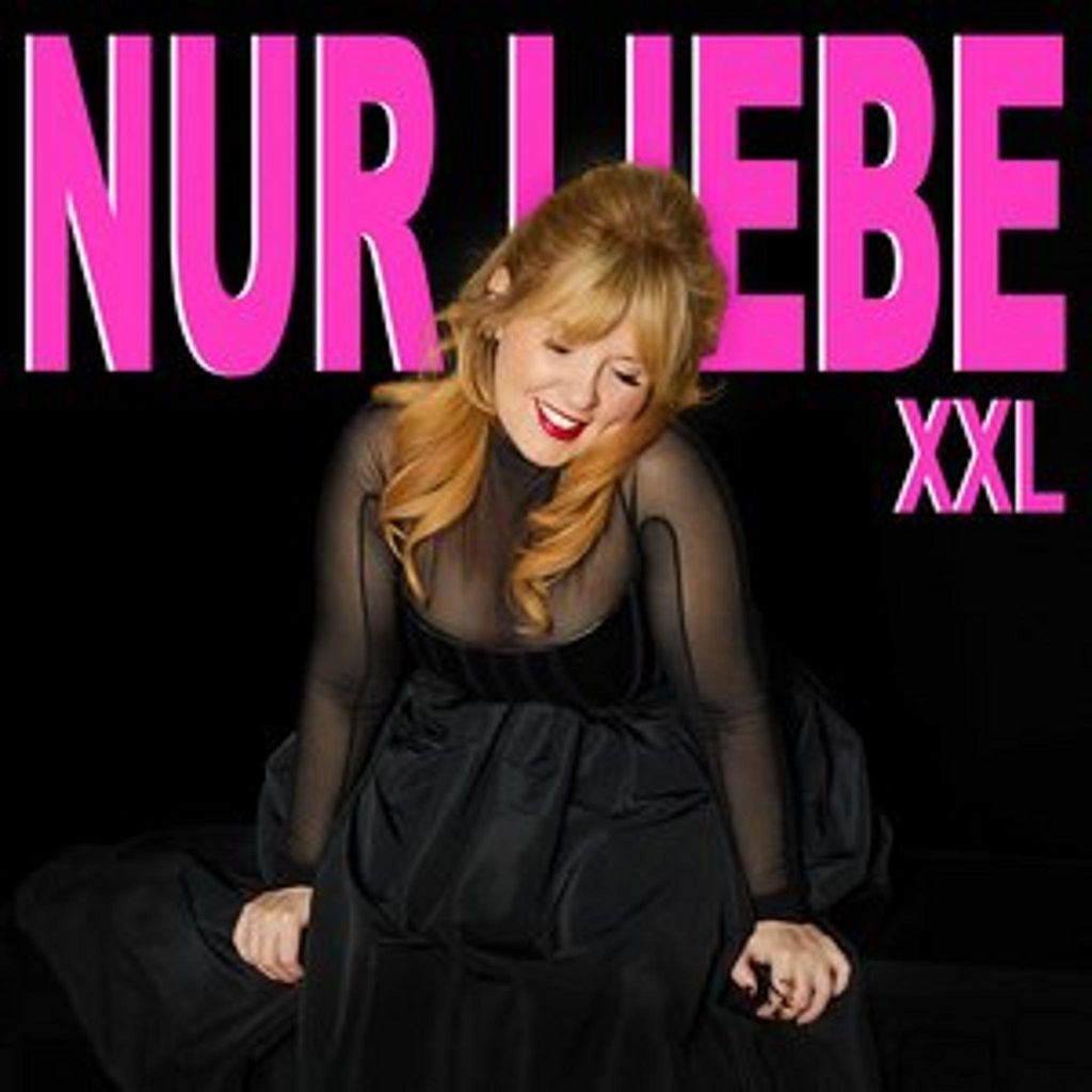 A woman in a black dress is posing in front of a black background with text.