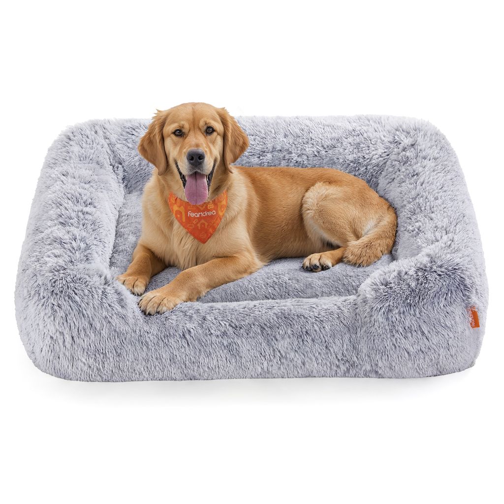 A golden retriever dog is lying on a plush gray dog bed.