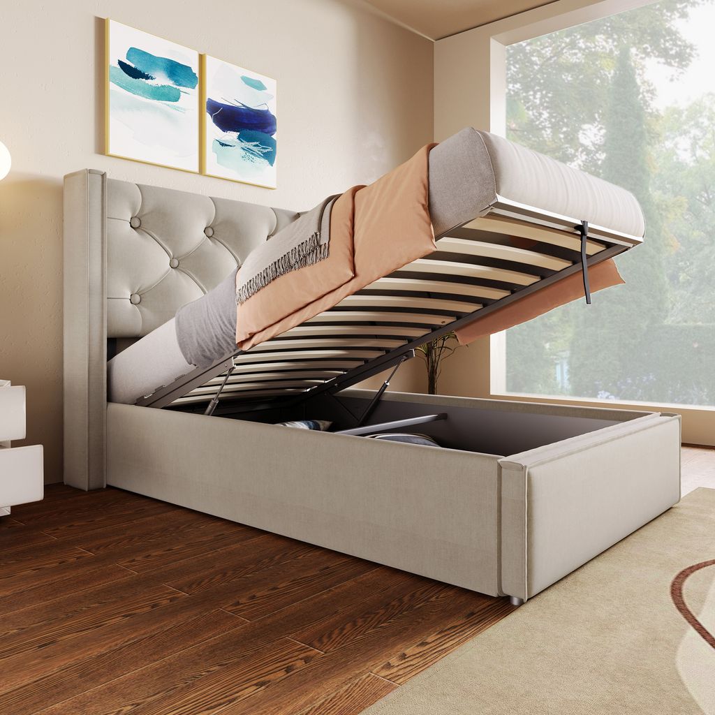 A bed with its storage compartment open, revealing the mattress and bedding. The room has wooden floors and a large window.