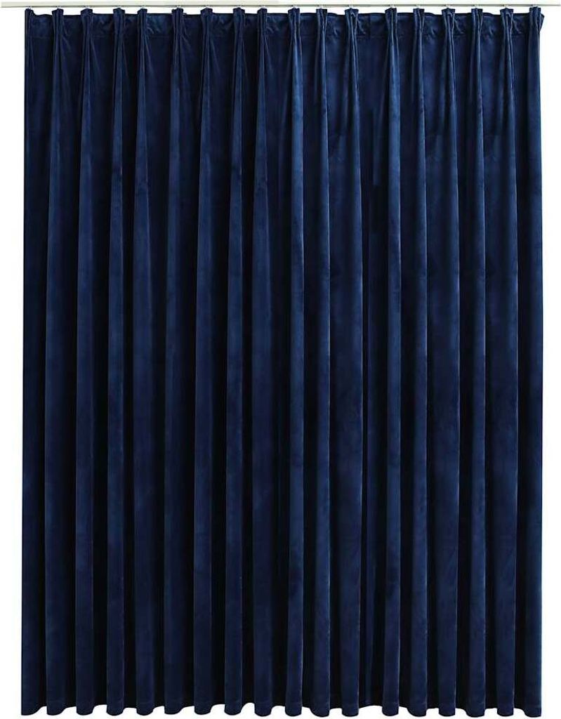 A full-frame shot of a dark blue velvet curtain hanging from a rod.