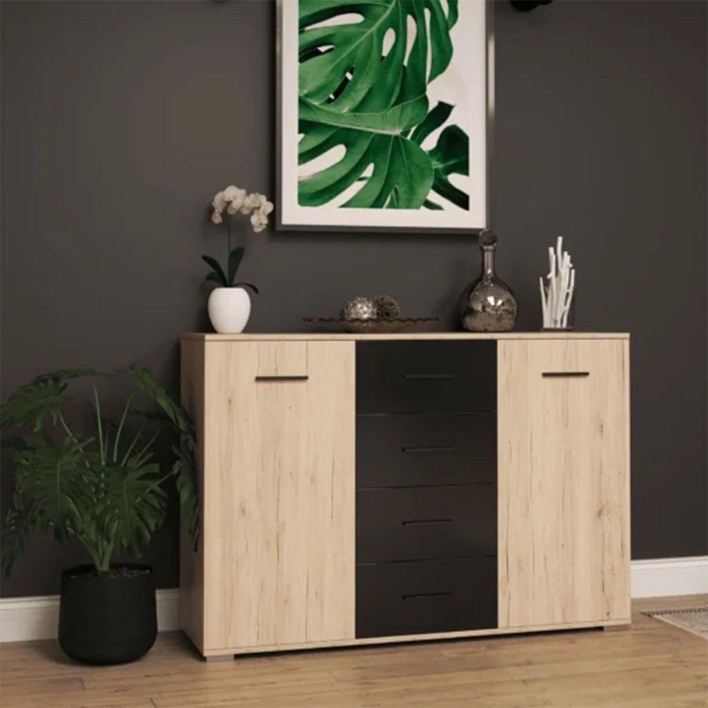 A modern sideboard with a wood-tone and black finish, decorated with a plant and decorative items, set against a dark gray wall.
