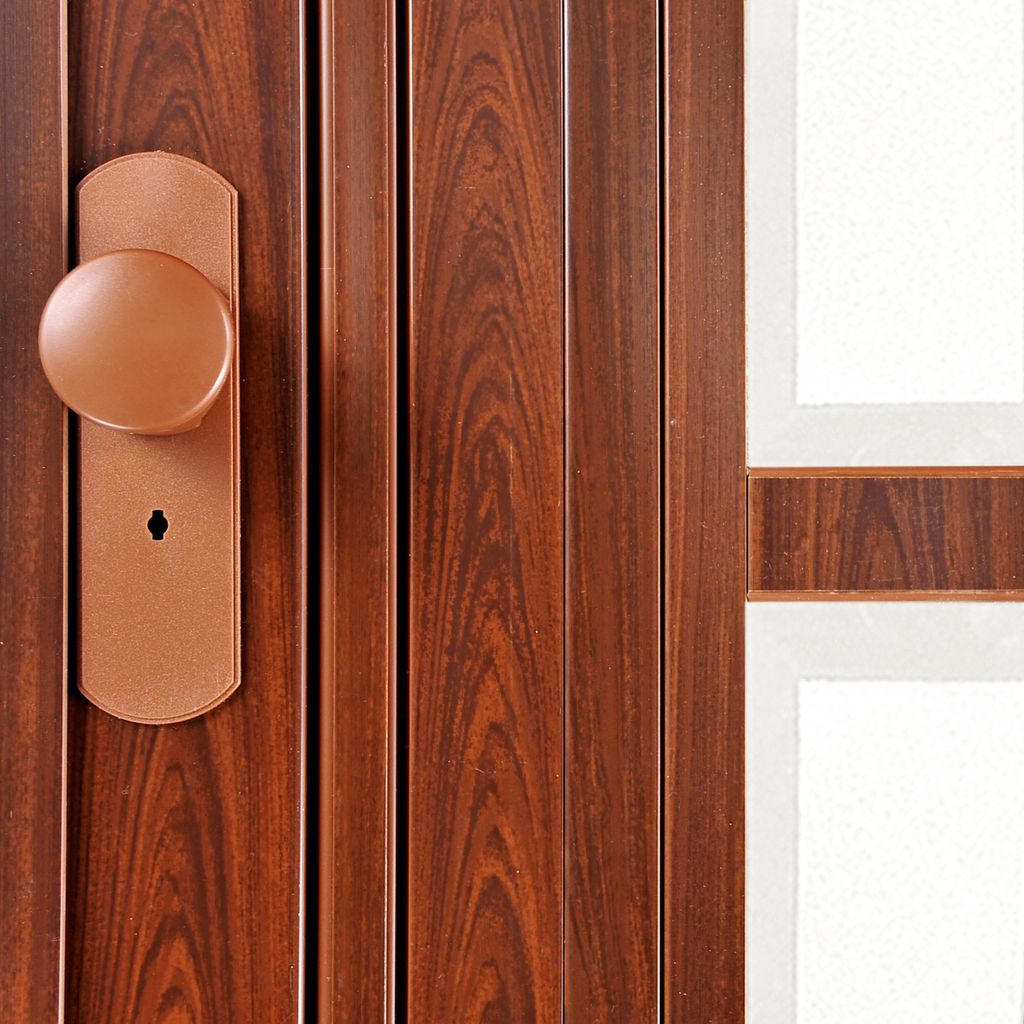 A close-up view of a wooden door with a doorknob and keyhole.