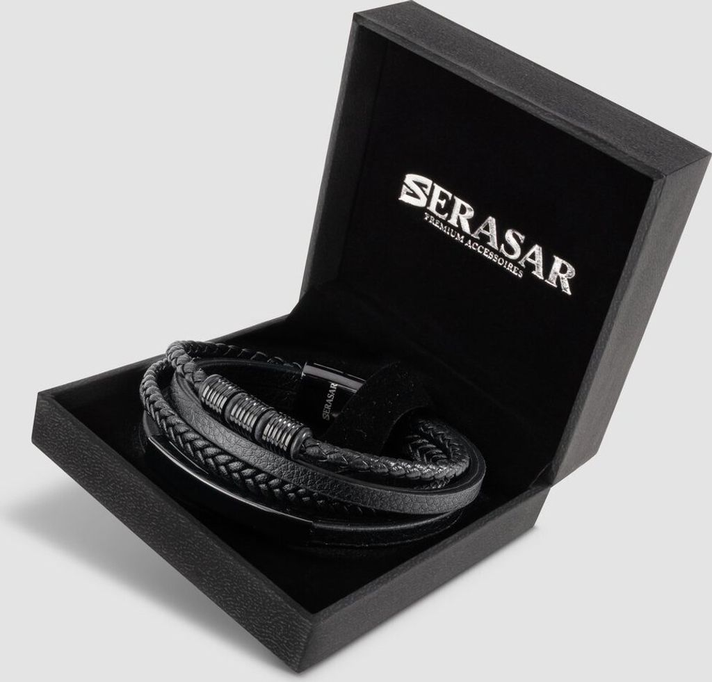 A black leather bracelet is displayed inside an open black gift box with the brand logo on the inside lid.