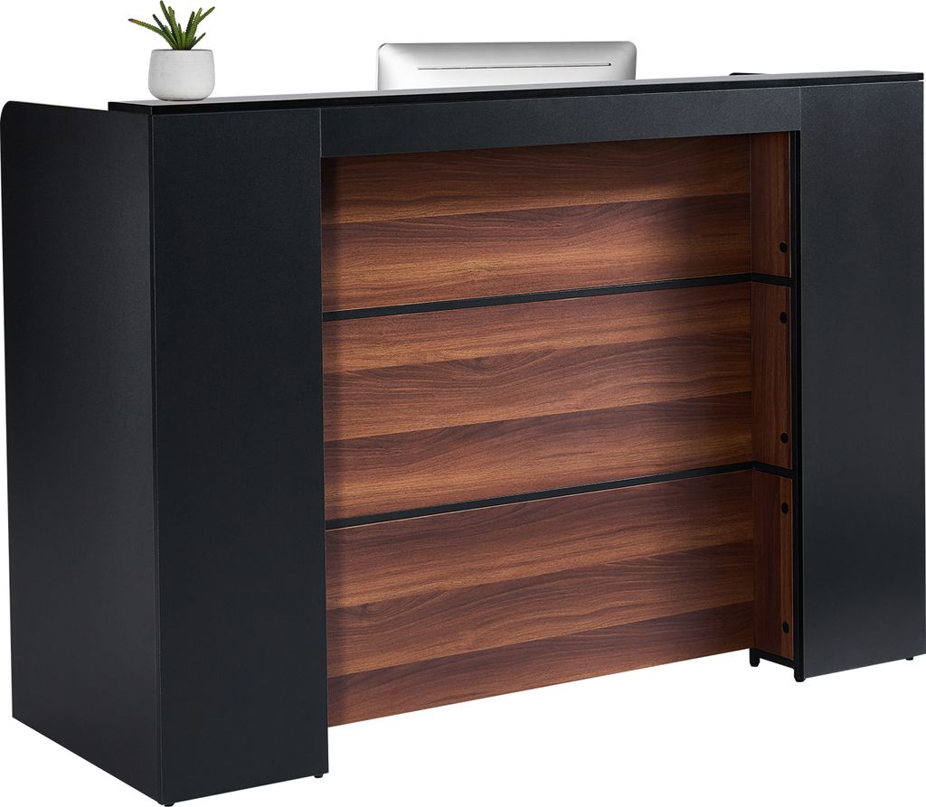 A reception desk with a wooden front and black sides, with a small plant and a computer monitor on top.