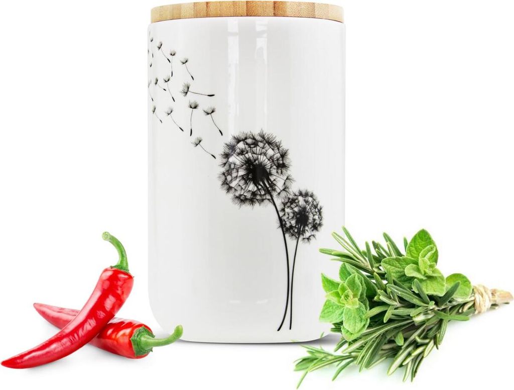 A white ceramic storage jar with a dandelion design, placed next to red chili peppers and a bundle of fresh herbs.