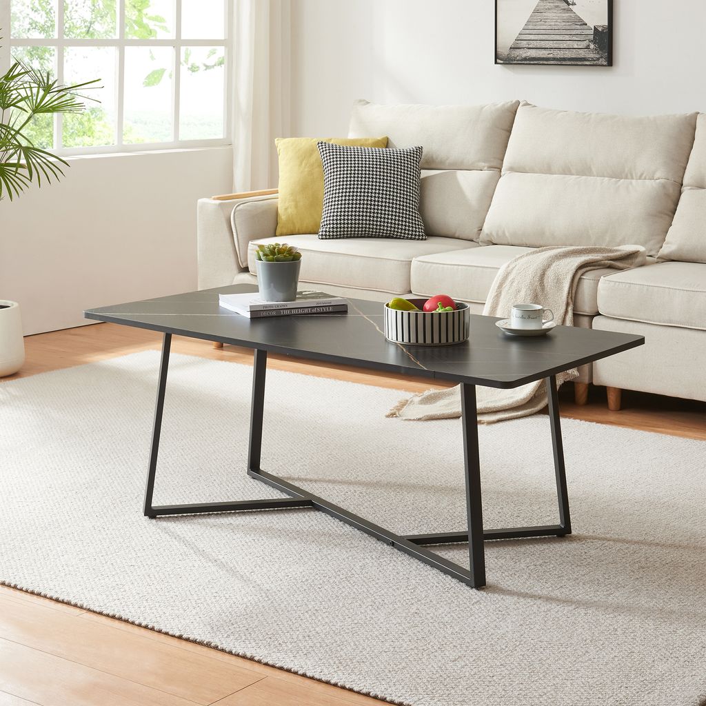 A modern living room scene with a couch, coffee table, and rug.