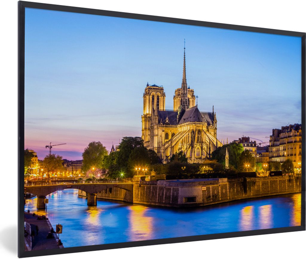 MuchoWow Gerahmtes Poster Eine beleuchtete Notre Dame mit blauem Wasser vor ihr in Frankreich 90x60 cm - Poster mit Schwarzem Bilderrahmen Wandpo...