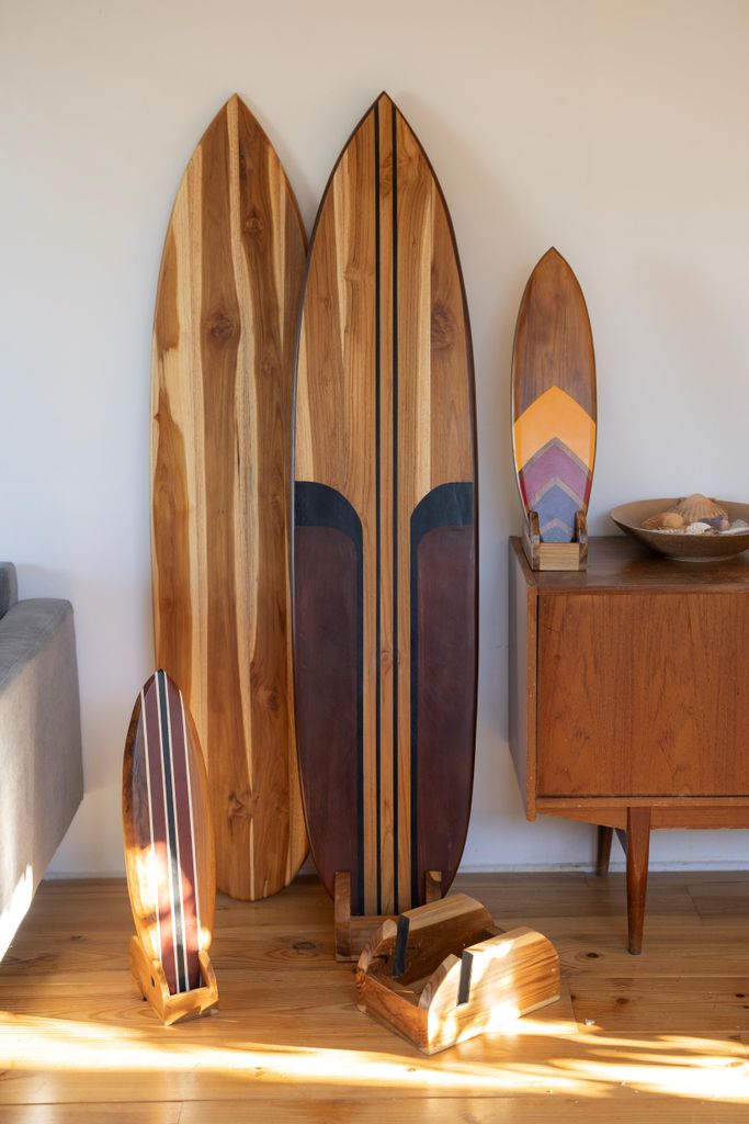 A collection of decorative wooden surfboards displayed indoors against a white wall.