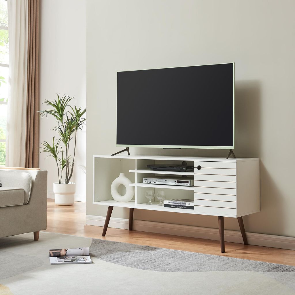 A modern living room with a TV stand, TV, sofa, and plant.