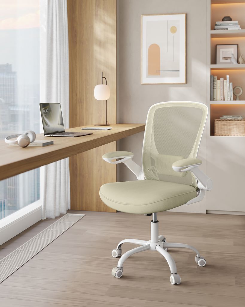 A modern home office setup with a desk, laptop, headphones, and an ergonomic chair.