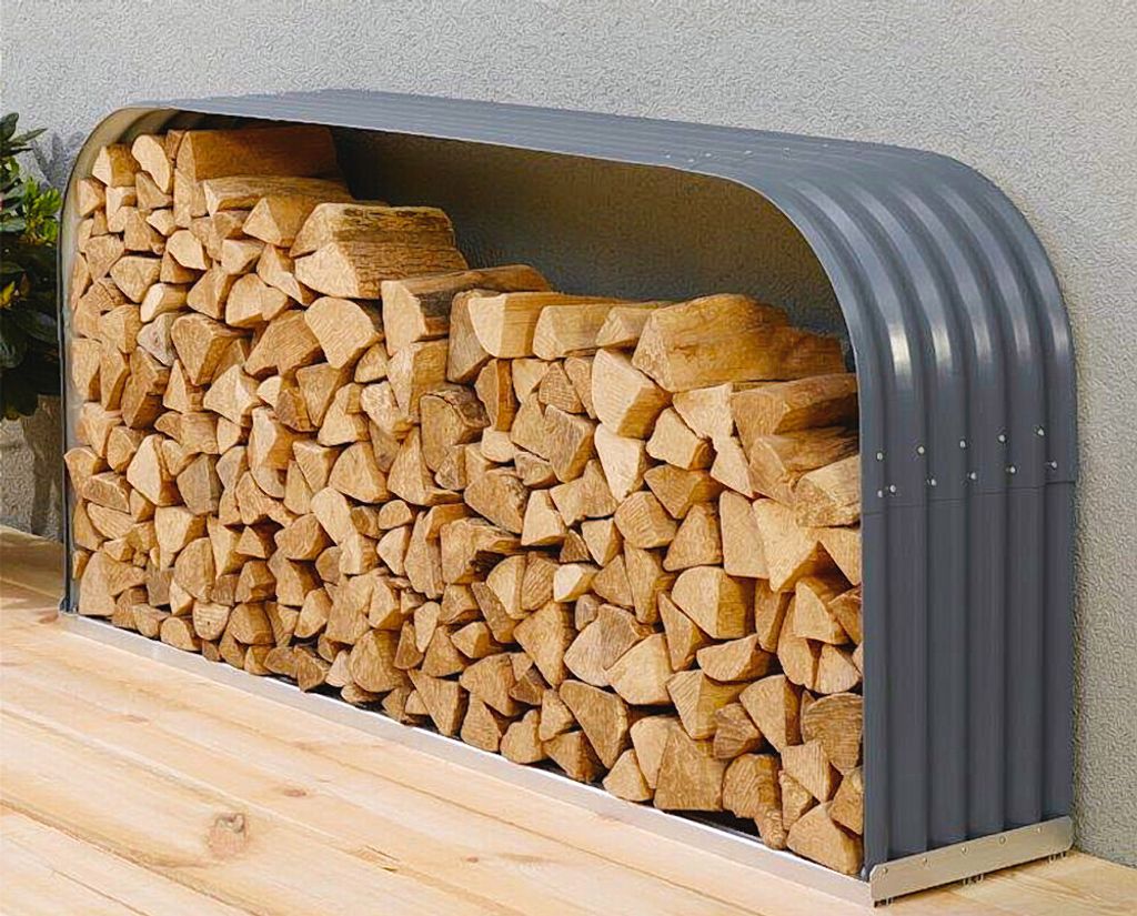A firewood rack filled with logs, placed on a wooden deck against a textured wall.