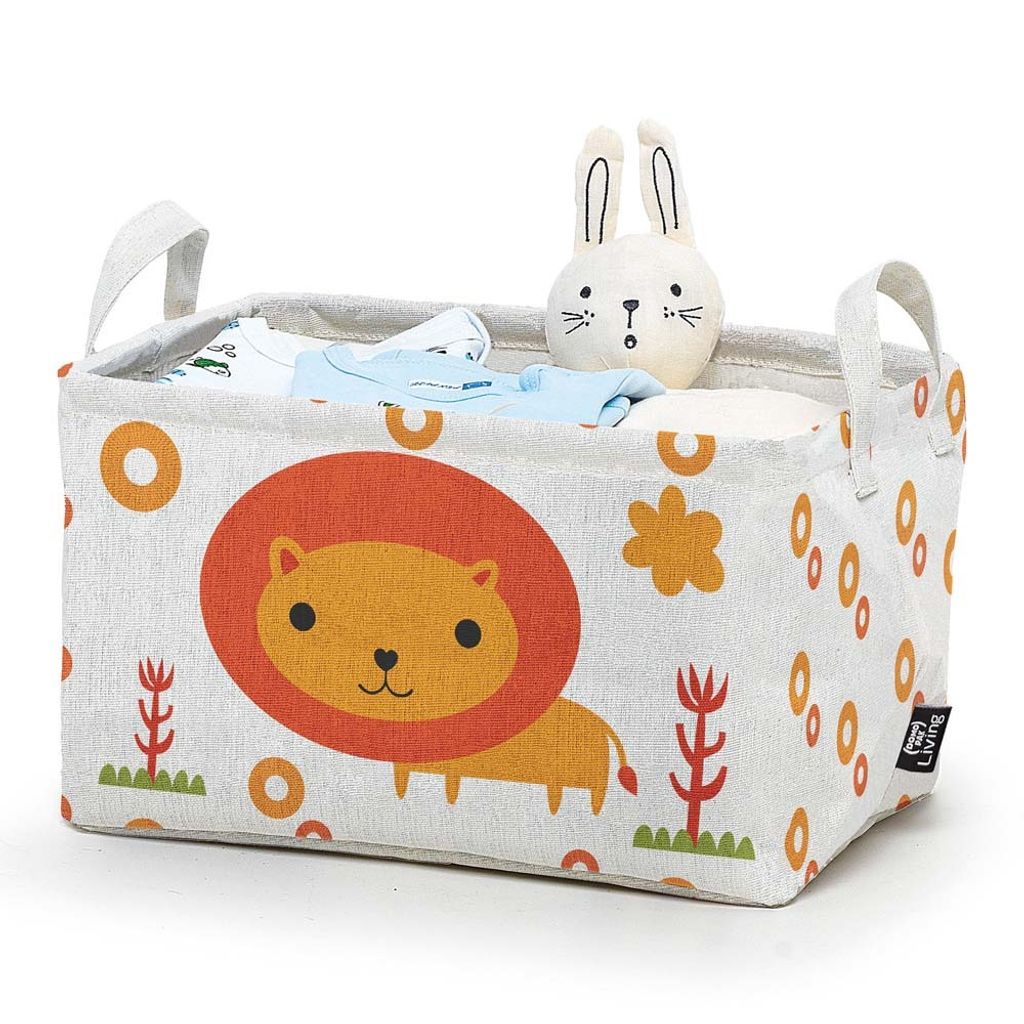 A rectangular fabric storage basket for children, decorated with a lion and other playful patterns, filled with baby clothes and a stuffed bunny.