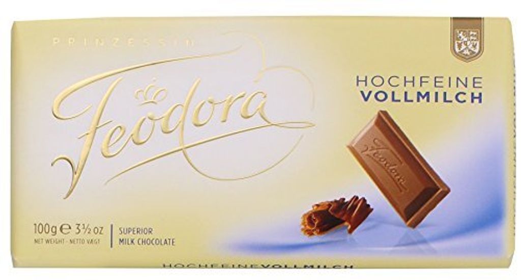 A chocolate bar wrapper with a piece of chocolate and chocolate shavings.