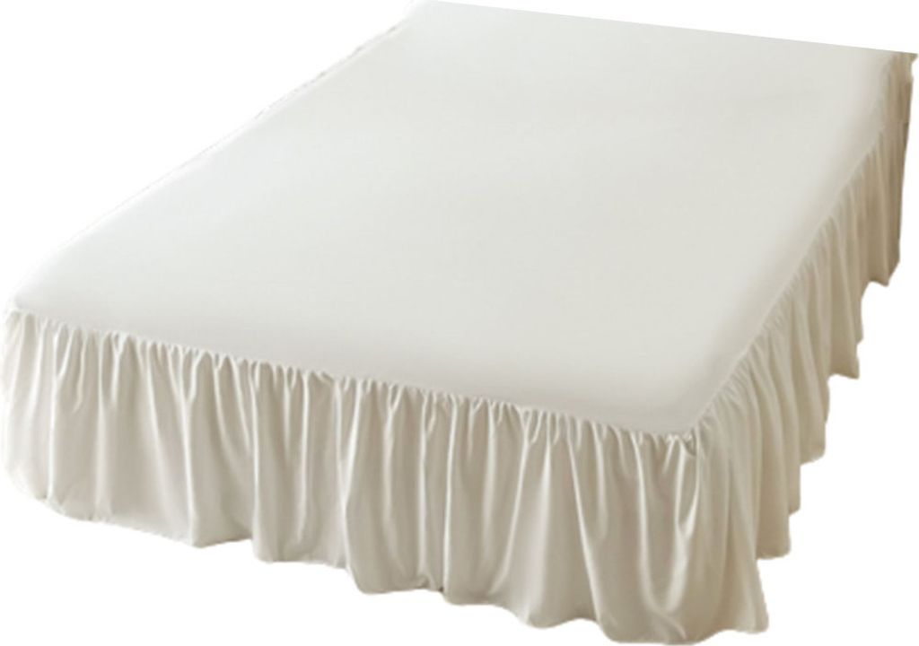 A white bed skirt with ruffles is shown on a bed.