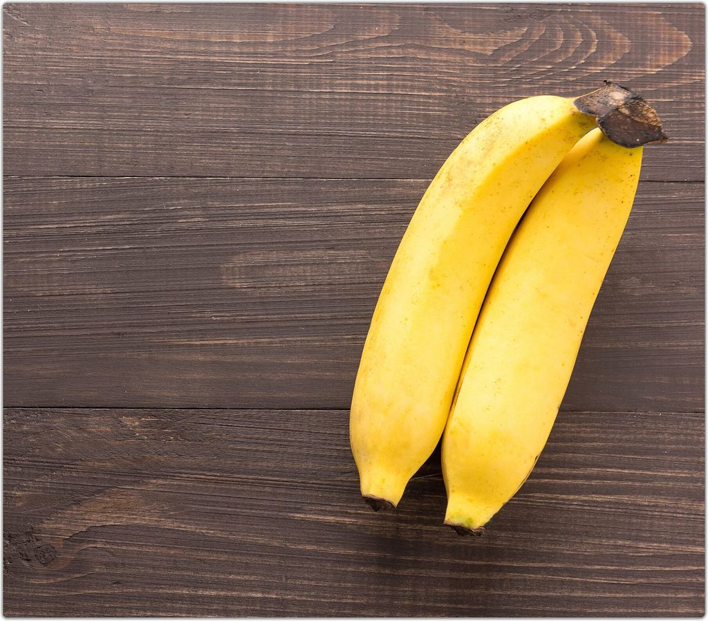 Spritzschutz Herdabdeckplatte Schneidebrett aus Glas Bananen auf Tisch 1-Teilig (60x52cm)