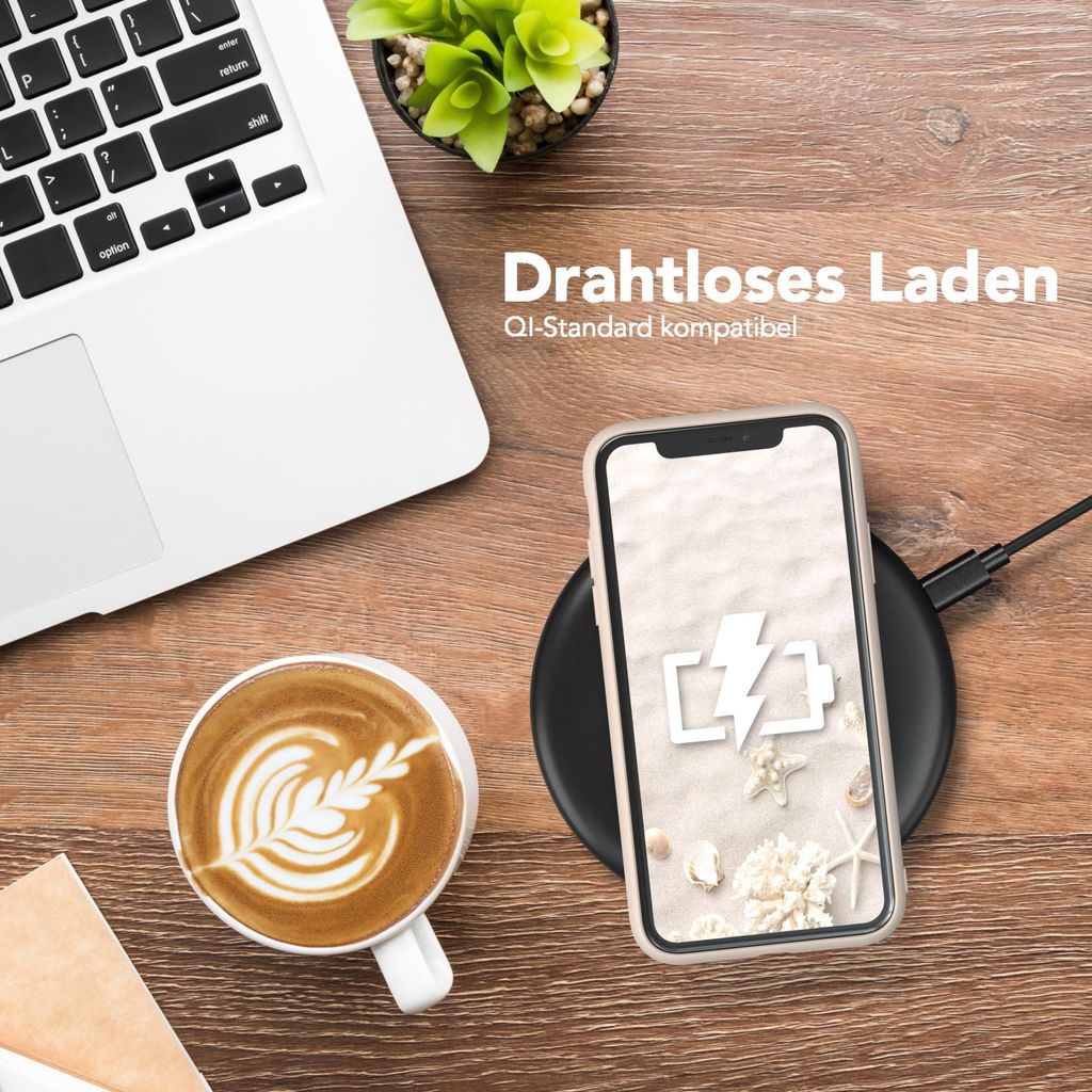 A desk scene with a laptop, coffee, and a smartphone charging wirelessly.