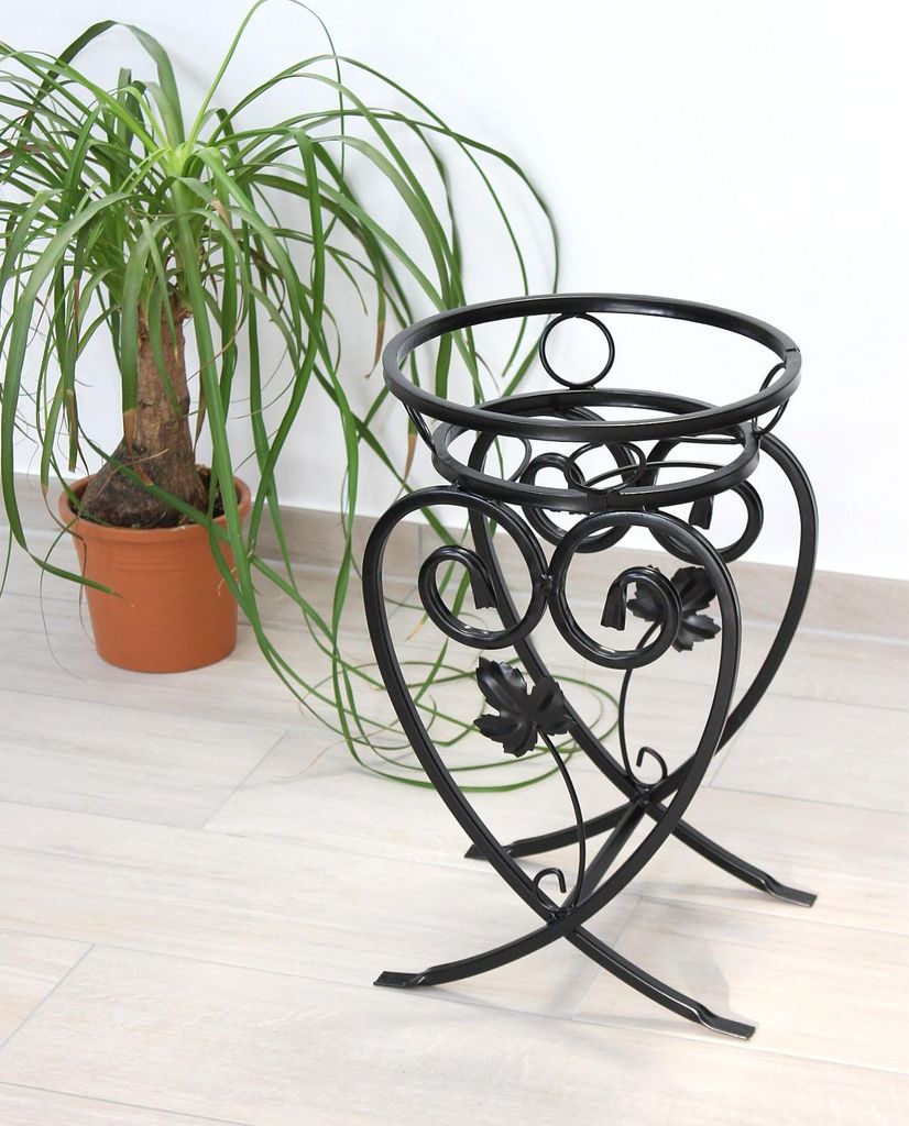 A black metal plant stand is shown next to a potted plant.