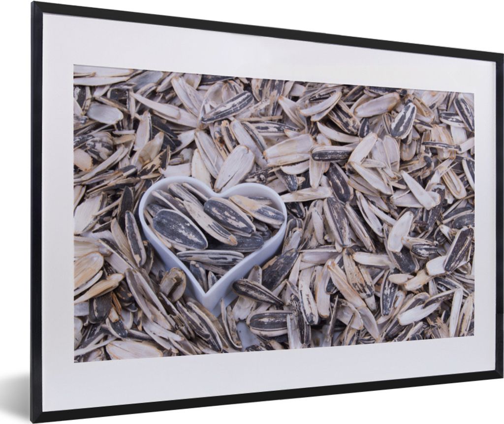 MuchoWow MuchoWow Gerahmtes Poster Sonnenblumenkerne mit einem herzförmigen Aussehen zwischen den Kernen 60x40 cm - Poster mit zchwarzem Bilde...