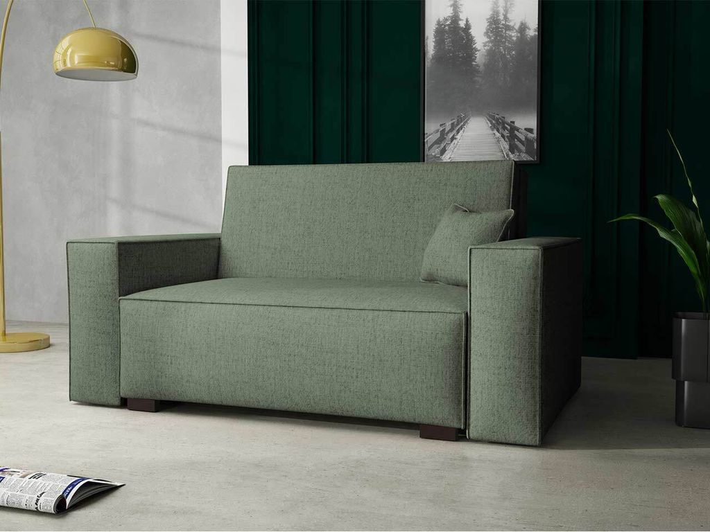 A green sofa is shown in a modern living room setting with a lamp and a plant.