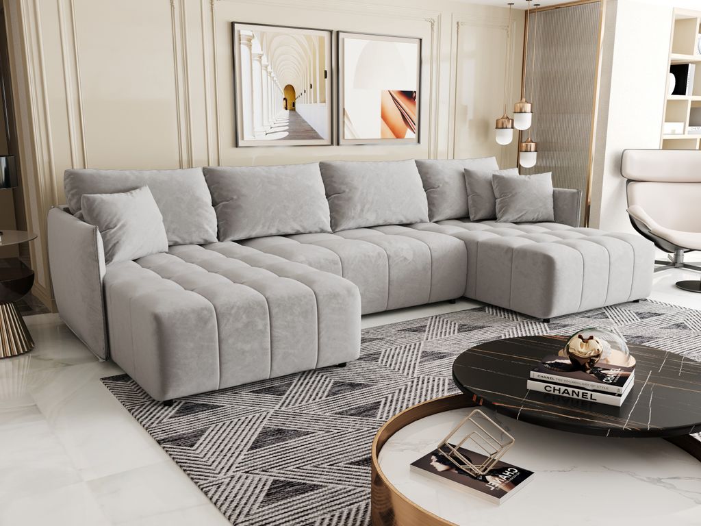 A modern living room with a large sectional sofa, coffee table, and artwork on the wall.