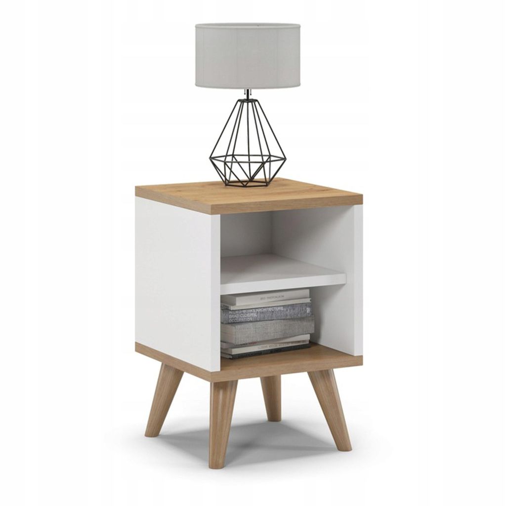 A white and oak bedside table with a lamp on top and books on the shelf.