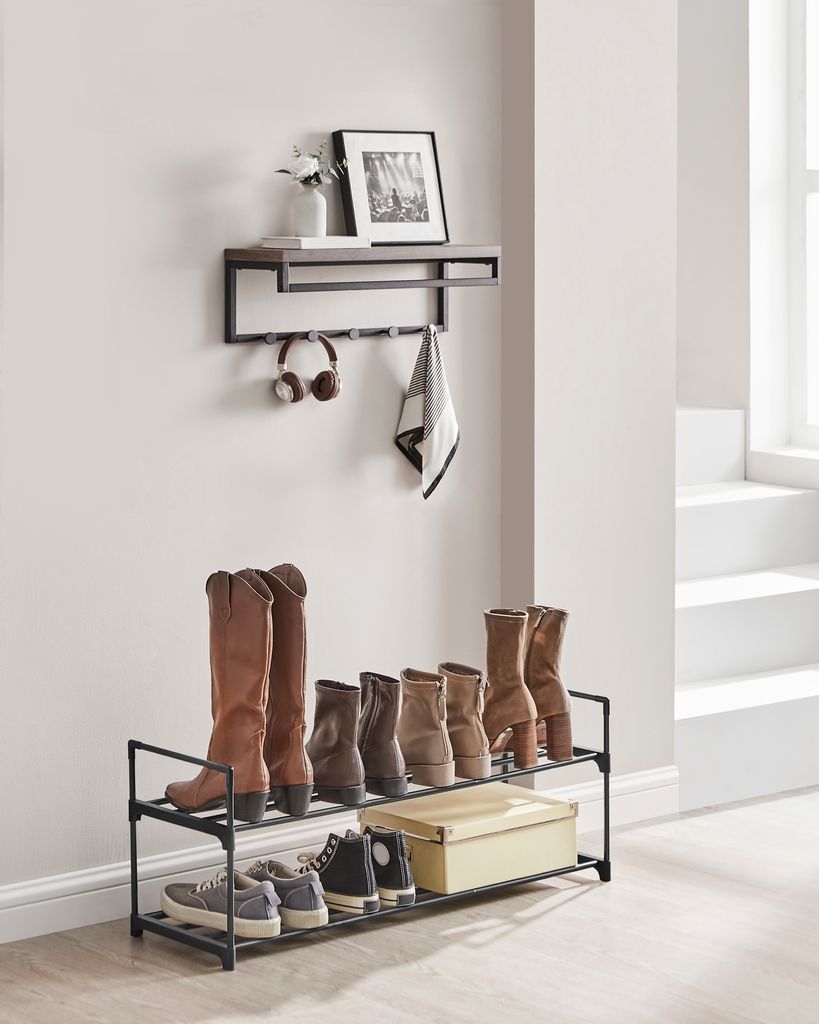 A shelf and shoe rack setup against a wall with a window and stairs in the background.
