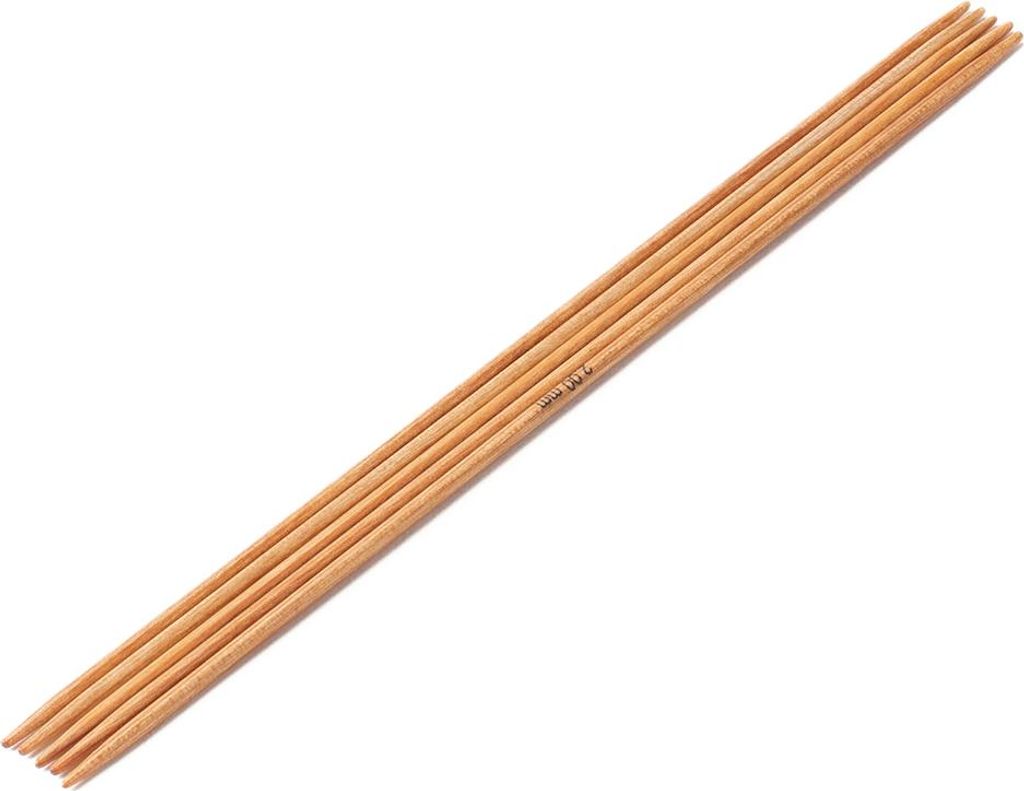 A set of wooden knitting needles laid out diagonally on a white background.