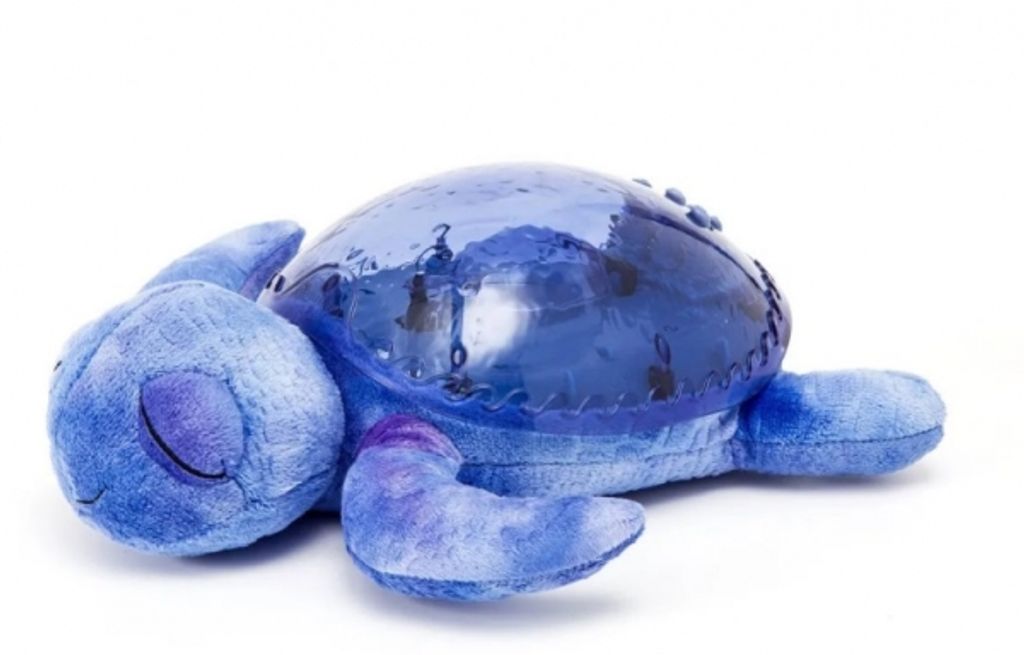 A plush toy turtle lying on its back on a white background.
