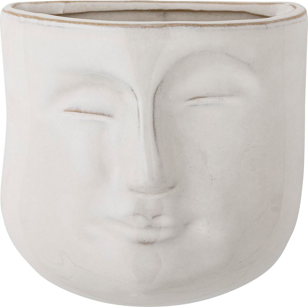 A white ceramic planter shaped like a face with closed eyes.