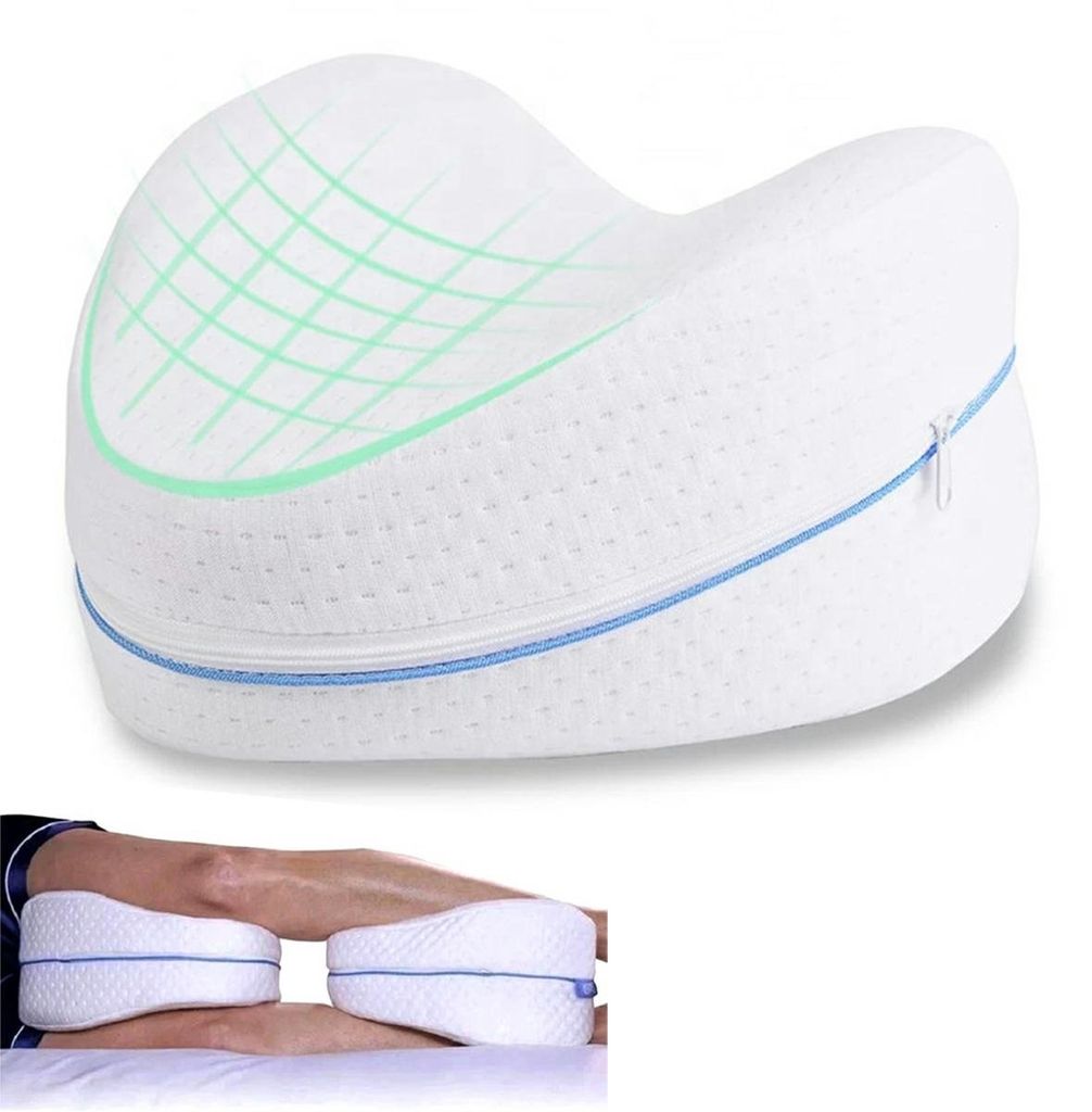 A white memory foam knee pillow with green grid pattern and blue zipper, shown in use between a person's legs.