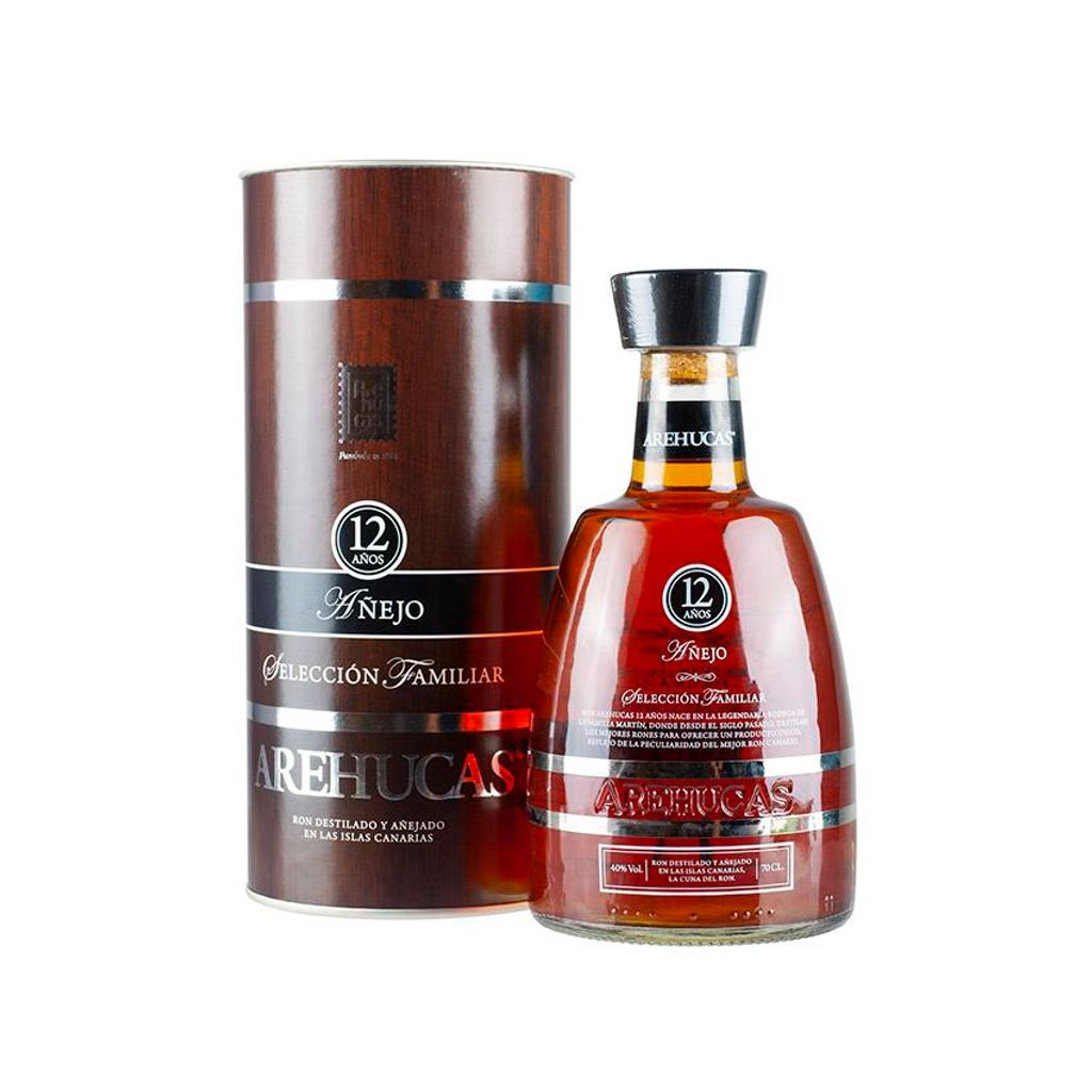 A bottle of Arehucas rum and its cylindrical packaging.