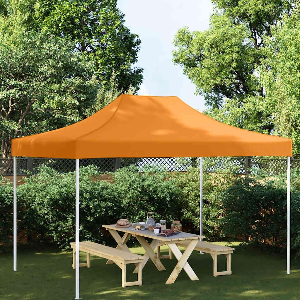 An orange party tent is set up in a garden with a picnic table and benches underneath.