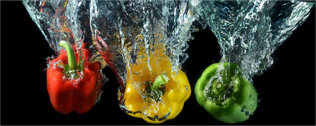 Wallario selbstklebendes Poster - Paprika-Mix - frische Paprika in rot, gelb und grün im Wasser, Größe: 50 x 125 cm
