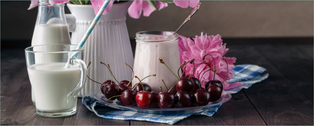 Wallario Poster - Milch mit Kirschen zum Frühstück mit rosa Blumenarrangement, Kunstdruck Größe: 80 x 200 cm