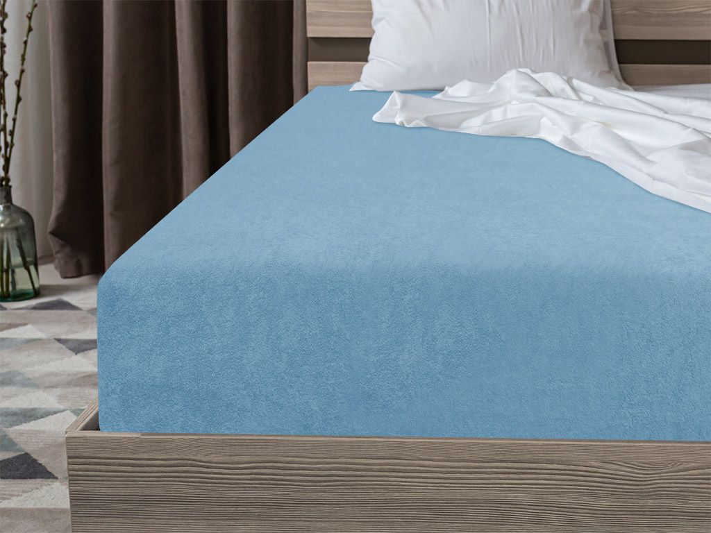 A close-up view of a light blue fitted sheet on a bed.