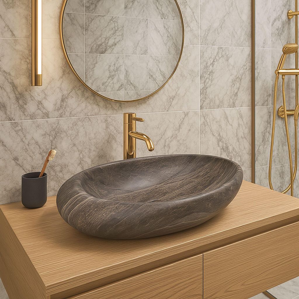 A modern bathroom vanity with a stone vessel sink and gold faucet.