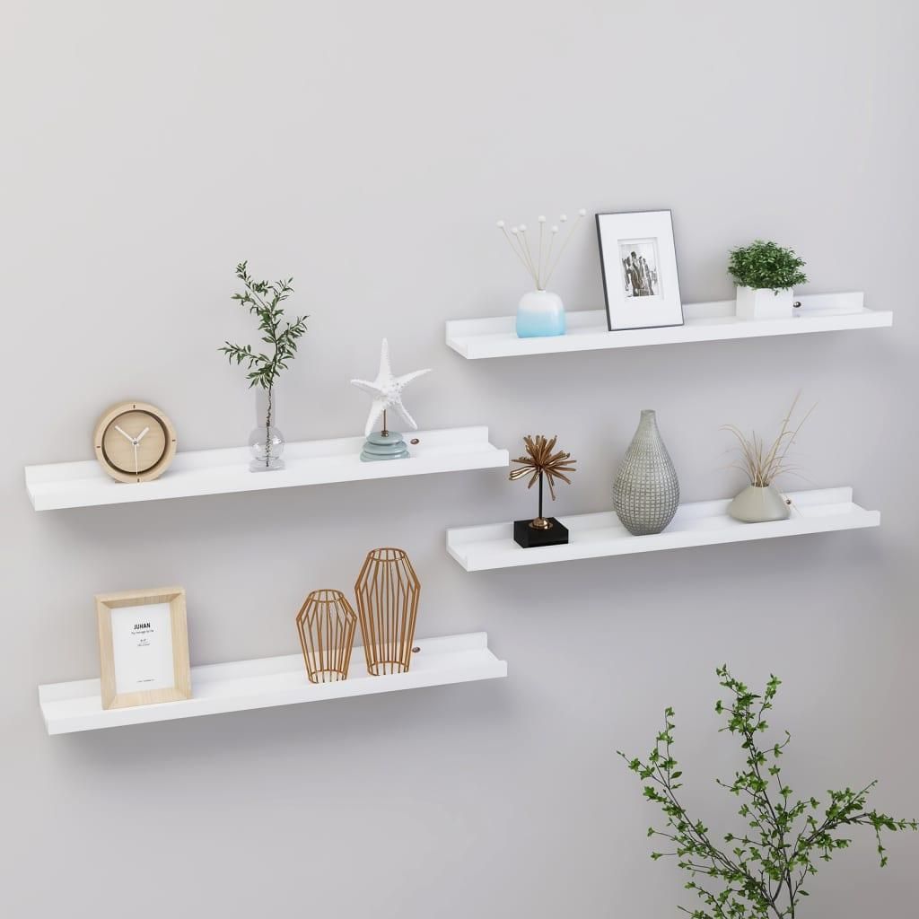 Four white wall shelves are mounted on a light gray wall, decorated with various items.