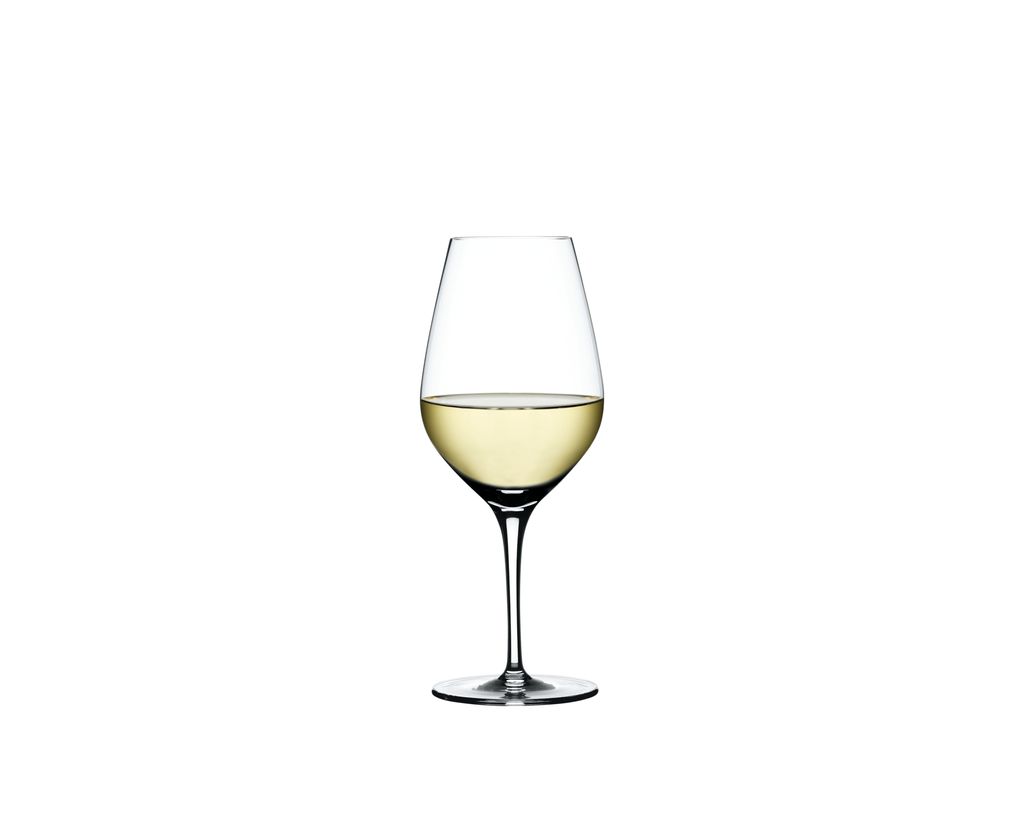 A single glass of white wine on a white background.