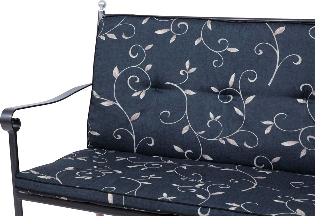 A close-up view of a dark blue bench cushion with a white vine and leaf pattern.