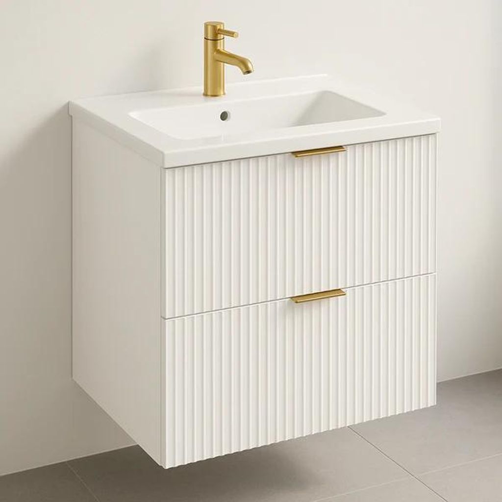 A white wall-mounted bathroom vanity with a sink and a gold faucet.