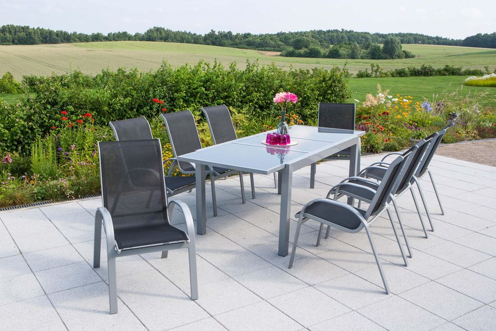 An outdoor patio setting with a dining set and a scenic landscape in the background.