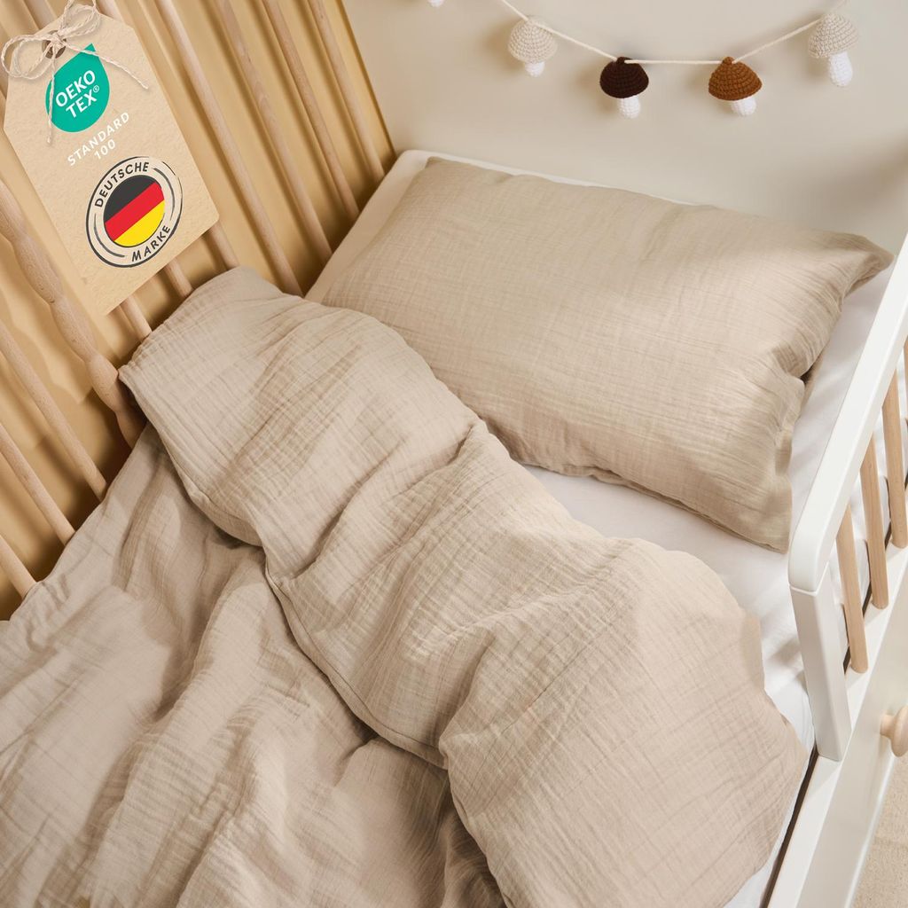 A close-up view of taupe-colored children's bedding in a crib.