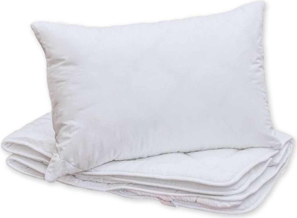 A white pillow is placed on top of a folded white blanket.