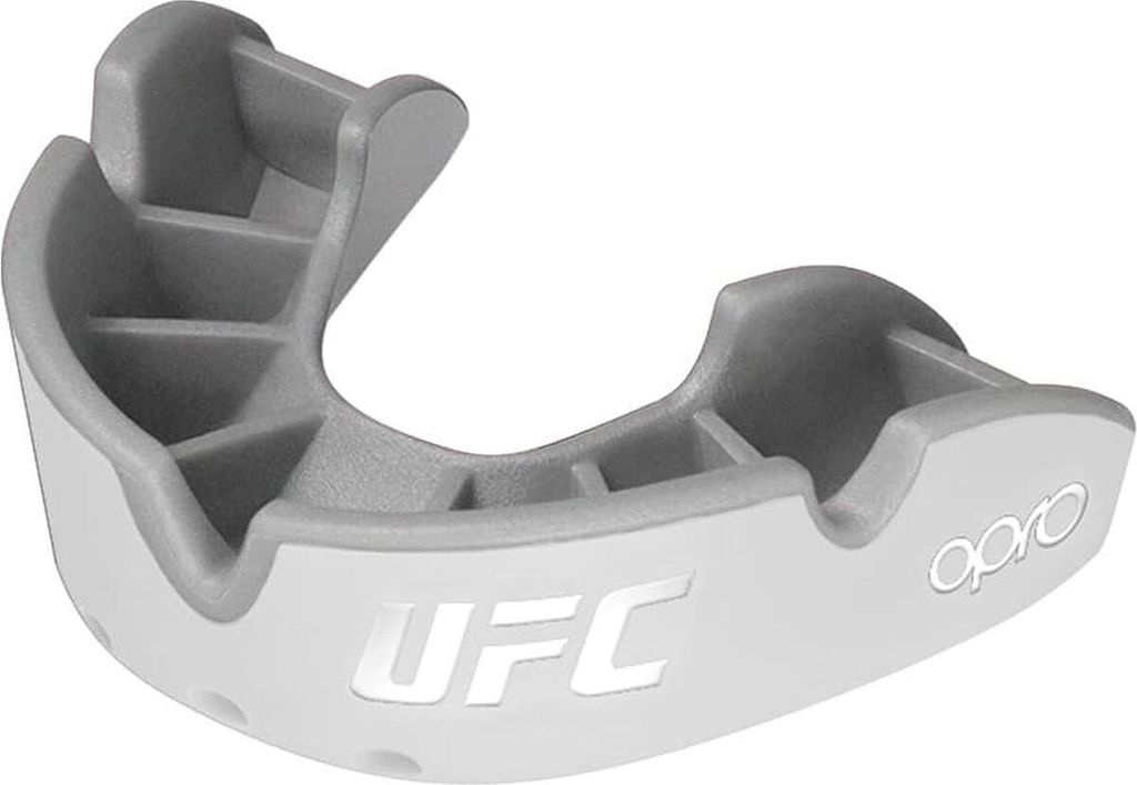 A close-up studio shot of a white and gray UFC branded mouthguard.