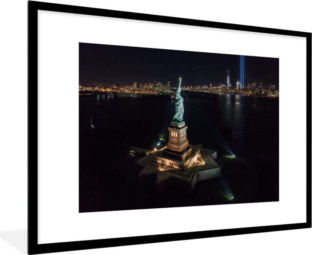 MuchoWow Gerahmtes Poster Die amerikanische Statue bei Nacht mit einem beleuchteten New York im Hintergrund 90x60 cm - Poster mit Schwarzem Bilde...