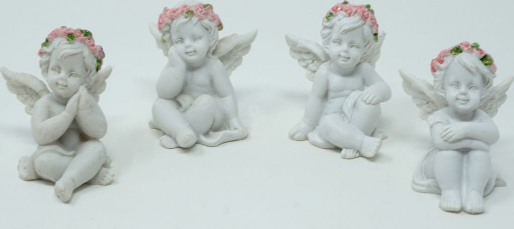Four white cherub figurines with pink and green flower wreaths on their heads, sitting on a white background.