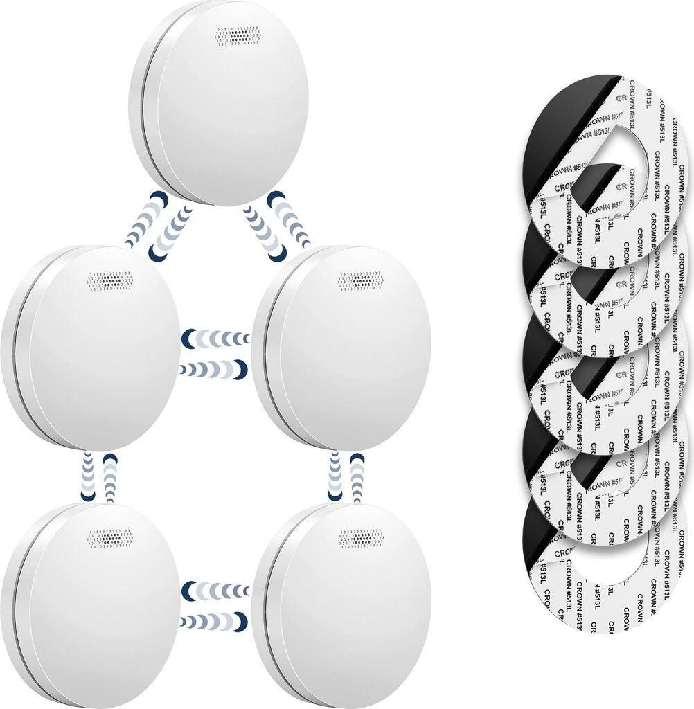 A set of interconnected smoke detectors arranged in a network formation, with a stack of adhesive mounting pads to the right.