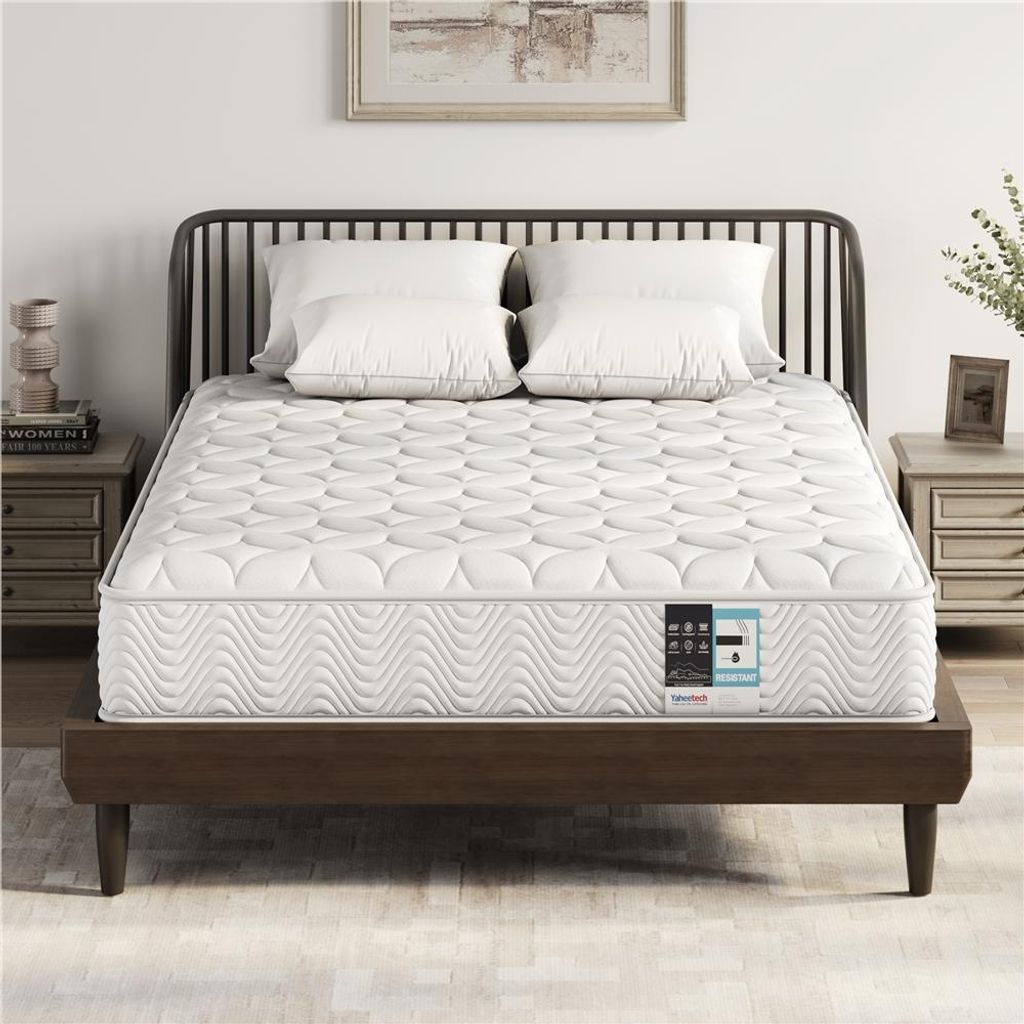 A mattress is displayed on a bed frame with pillows.