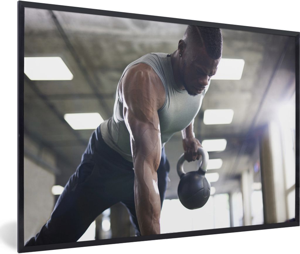 MuchoWow Gerahmtes Poster Ein starker Mann hebt Kettlebells beim Fitness 90x60 cm - Poster mit Schwarzem Bilderrahmen Wandposter Rahmen Foto Bild...
