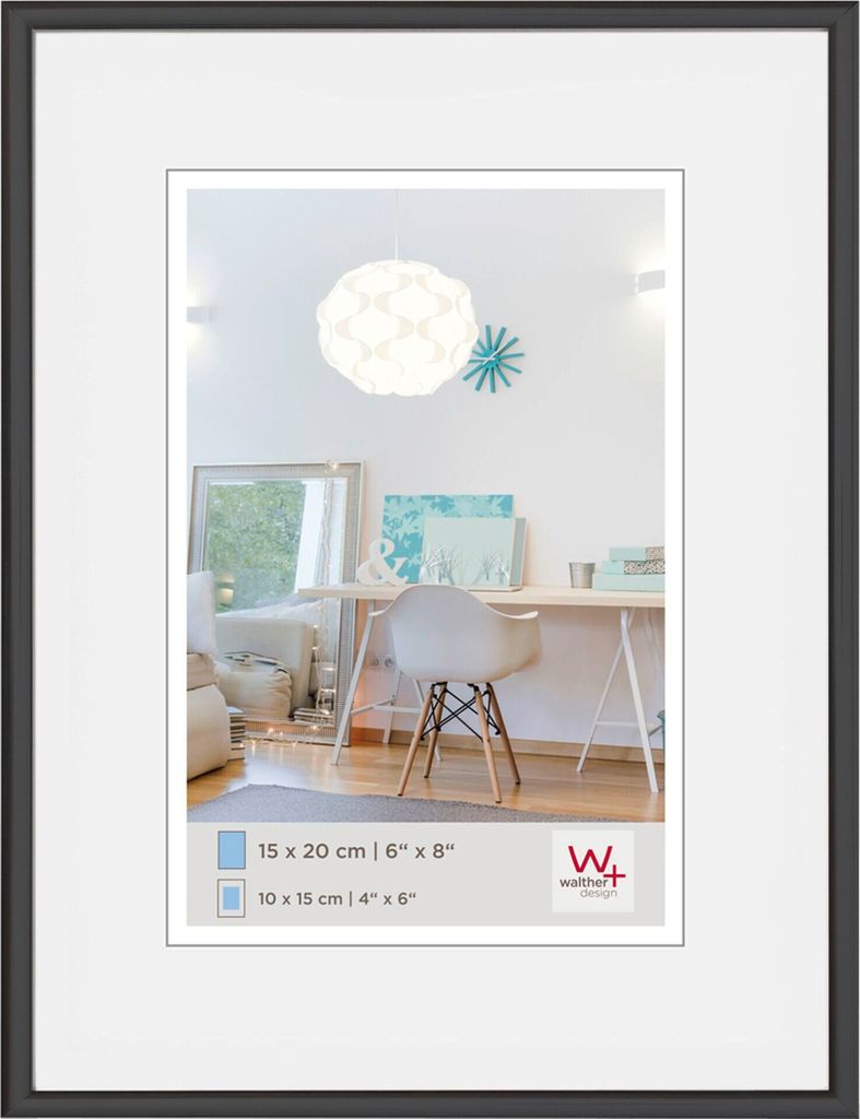 A framed picture of a desk area with a chair and a lamp.